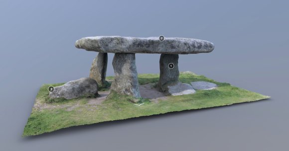 Screenshot of a 3D model of Lanyon Quoit. Three upright stones on a rectangular bed of grass support a huge granite capstone. Three white numbers are visible on black backgrounds attached to several parts of the quoit. These can be clicked to read more information.