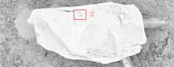 A black-and-white image looking down from the air onto the top of the capstone at Lanyon Quoit. This computer-generated image is akin to a rubbing done with chalk and paper. The darker areas are cut in to the stone - where our metaphorical chalk cannot get into the crevices - and the white areas are easily covered. Thus, the initials LN and JB (one above the other) can be easily spotted as they have been carved. These are highlighted by a red box on this image.